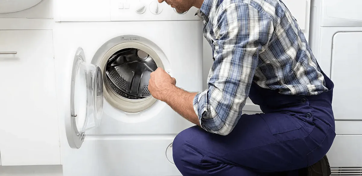 Handyman inspecting a dryer drum and internal parts for repair in Memphis, TN