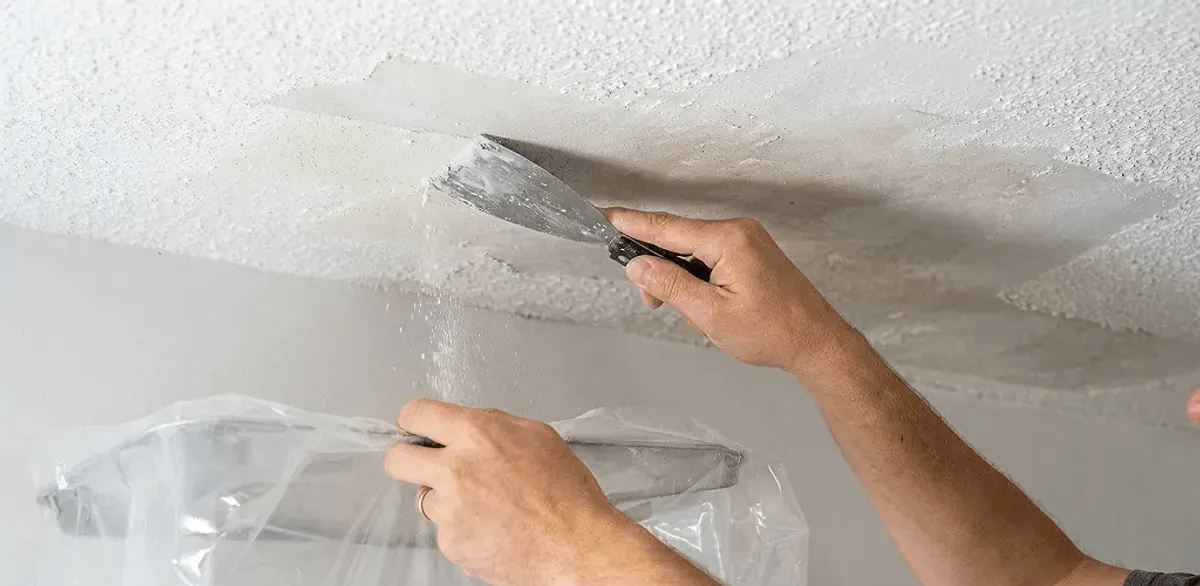 Popcorn ceiling removal technician scraping texture from a ceiling in Memphis, TN