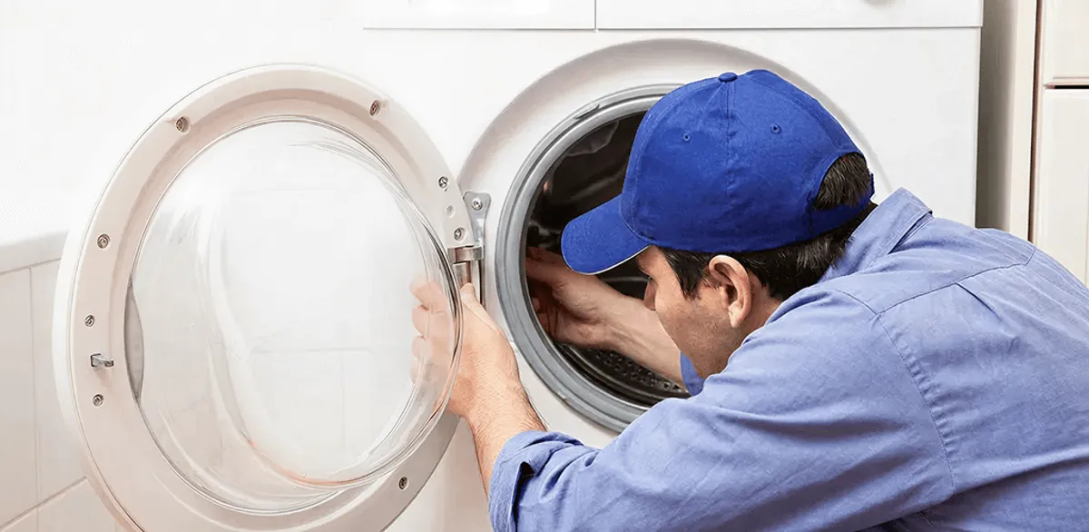 Washing machine repair handyman inspecting a front-load washer drum in Memphis, TN